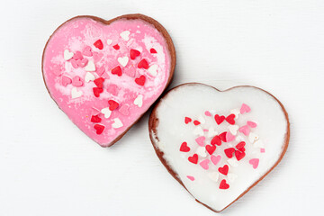 Obraz na płótnie Canvas one pink and one white heart-shaped gingerbreads on white background
