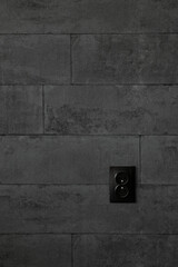 double black socket on a dark brick wall