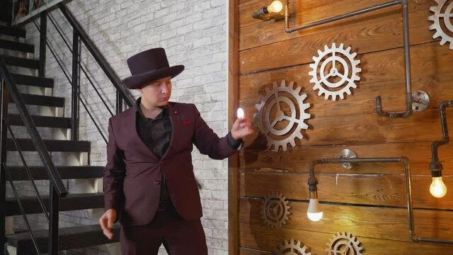 The magician shows trick with a light bulb. Magical lighting of a light bulb. Businessman demonstrating magic. Magician at work. Entertainer performing magic tricks with light bulb.