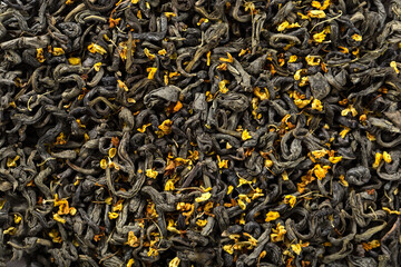 Texture of dry green tea with sweet osmanthus flowers. China oolong tea macro photography