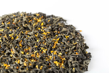 Texture of dry green tea with osmanthus flowers on a white background. China oolong tea macro photography