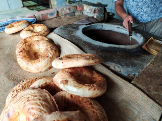 A man bakes cakes in a stone tandoor. Traditional Crimean Tatar and Muslim cuisine.