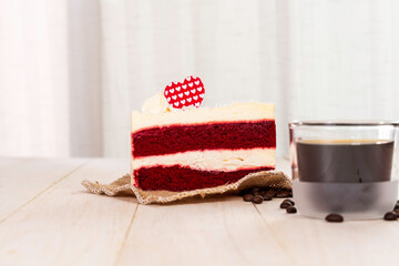 Slice of  Red velvet cake  and hot americano or black coffee on the wooden table with white curtain background. Valentines day.