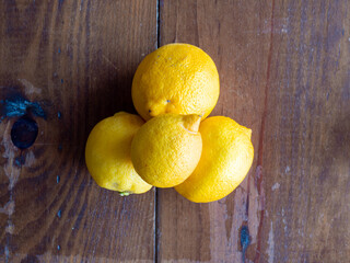 Top view of four lemons on wooden table