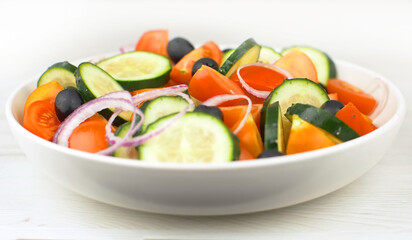 Mix fresh salad with red tomatoes, cucumber, onion and black olives