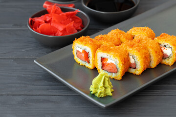 Sushi roll fried in tempura on black plate