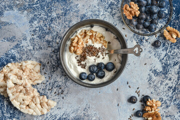 bowl of cottage cheese with blueberries, flax, walnut and spoon