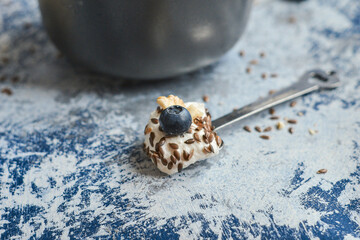 a spoon with cottage cheese on the background of a plate 