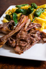 Grilled lamb ribs. Meat served with French fries and peppers. Vertical picture
