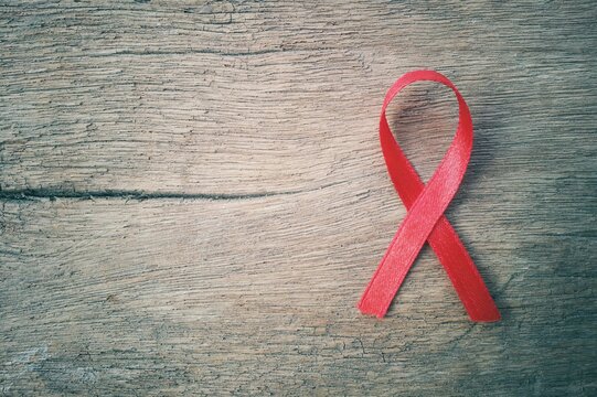 Directly Above Shot Of Red Cancer Awareness Ribbon On Table