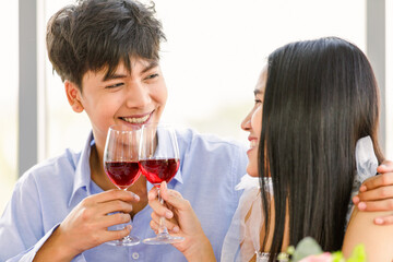 Asian man and woman eating food together in a restaurant with happy