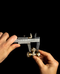 Plumber measures the size of brass fitting using a caliper before connecting water or gas pipe