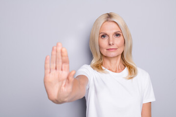 Fototapeta premium Portrait of blond sad old lady show no wear white cloth isolated on grey color background