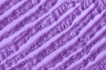 Fototapeta na wymiar Purple clay (alginate face mask, body wrap, make-up eyeshadow) texture close up, selective focus. Abstract lavender background with brush storkes.