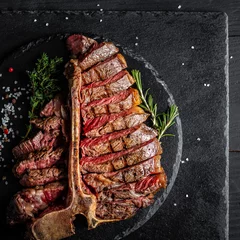 Fototapete Rund Dry Aged Barbecue Porterhouse Steak T-bone beef steak sliced with large fillet piece with herbs and salt. American meat restaurant. square image, top view © Надія Коваль