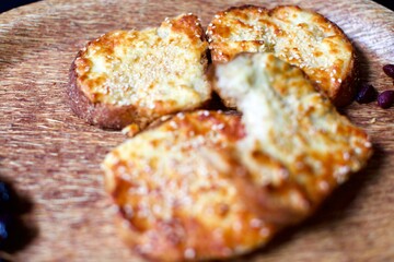 Toast with cheddar cheese and sesame seeds on a wooden tray. breakfast and snack