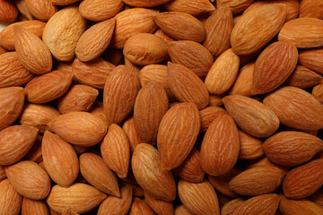 Tasty almond nuts on whole background, close up