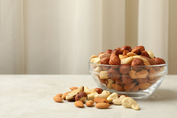 Bowl with different nuts on white textured table