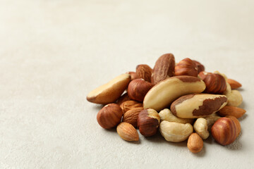 Heap of different nuts on white textured background