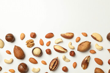 Different tasty nuts on white background, space for text
