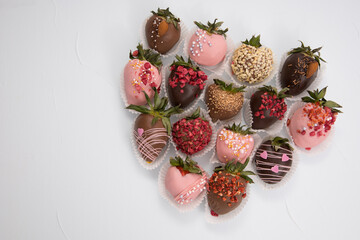 Assorted strawberries in chocolate, sweet dessert, free space for your text, sprinkled with nuts, top view, isolated background.