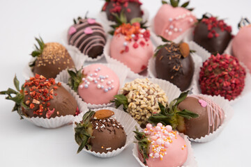 Assorted strawberries in chocolate, sweet dessert, free space for your text, sprinkled with nuts, top view, isolated background.