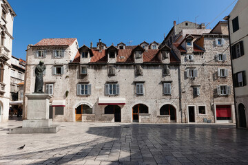 Obraz premium Old streets, architecture. Old facades and red tiled roofs. Scene from the old city of Split and the view of old bell tower