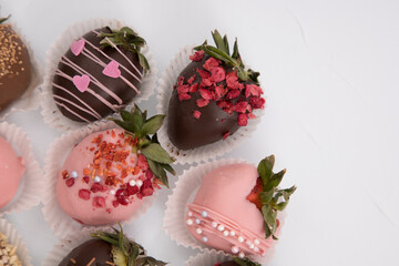 Assorted strawberries in chocolate, sweet dessert, free space for your text, sprinkled with nuts, top view, isolated background.