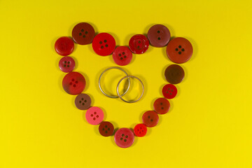 Two wedding rings and red heart made in buttons for Valentine's day