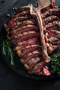 porterhouse steak is grilled sliced on a piece. grilled large t-bone steak garnished. Food recipe background. Close up. vertical image