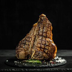 Dry Aged Barbecue Porterhouse Steak T-bone beef steak sliced with large fillet piece with herbs and salt. American meat restaurant. square image
