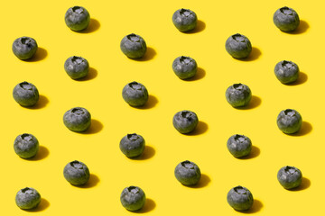 Minimalistic pattern of organic natural blueberries. Concept made on optimistic yellow background.
