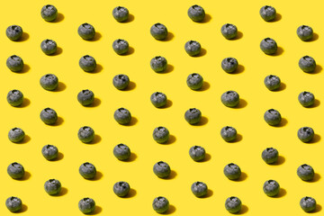 Minimal pattern of organic natural blueberries. Arrangements made with surreal yellow background.