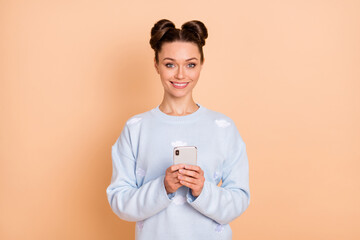 Photo of optimistic brunette lady stand hold telephone wear sweater isolated on pastel beige color background