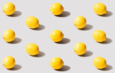 Minimal pattern of organic natural lemons. Arrangements  of yellow fresh fruits made with surreal gray background combination of colors of the year. 2021.