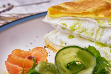 Close-up of an omelette la poulard served with green cucumber.