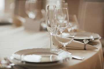 Table setting with plates, glasses and napkins for holidays dinner.