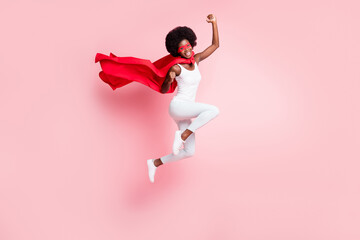 Full length body size view of active cheery girl jumping rejoicing wearing hero costume isolated on pink pastel color background - obrazy, fototapety, plakaty