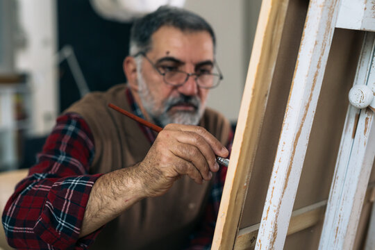 senior man painting the picture at his home