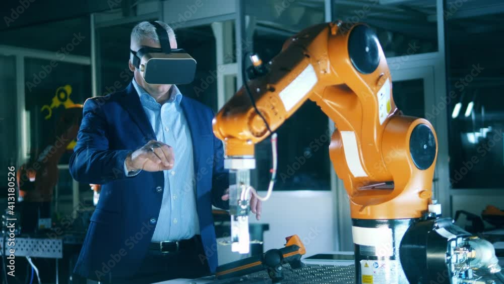 Wall mural male scientist is using a vr-device to operate a robot