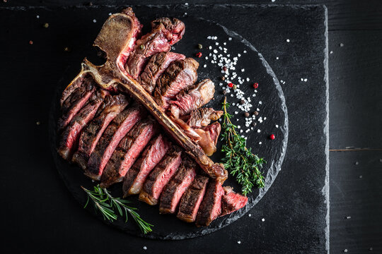 T bone steak is grilled sliced on a piece. Aged Barbecue Porterhouse Steak American meat restaurant served on slate board. banner, catering menu recipe place for text, top view