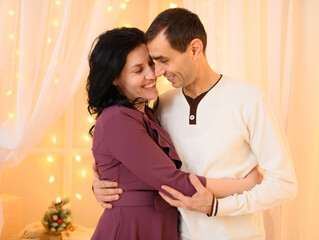 portrait of adult couple in home interior decorated with lights