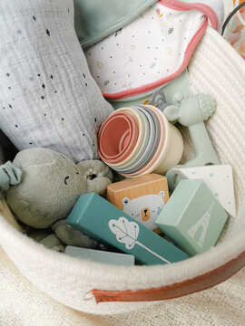 Gender neutral gift set for a baby shower with toys in soft colors.