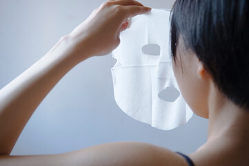 フェイスマスクをする女性の後ろ姿