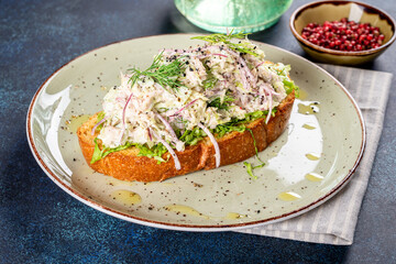 Sandwich with lingonberry and omul on a white round plate