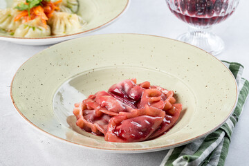 Red dumplings with cherries in a white plate filmed in decor