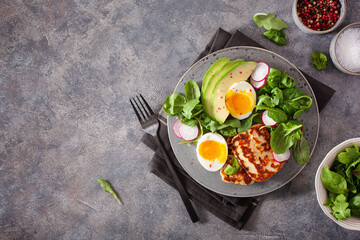 healthy keto paleo diet breakfast: boiled egg, avocado, halloumi cheese, salad leaves