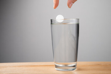 Sparkling tablet throw into a glass transparent glass, the glass is on a table