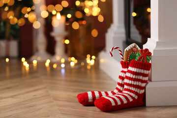 Socks filled with sweets on floor in room, space for text. Saint Nicholas Day