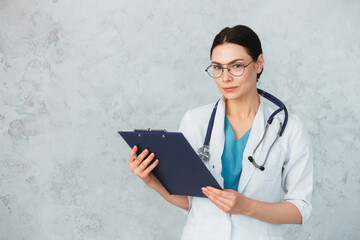 Young female doctor with stethoscope and folder. caucasian brunette